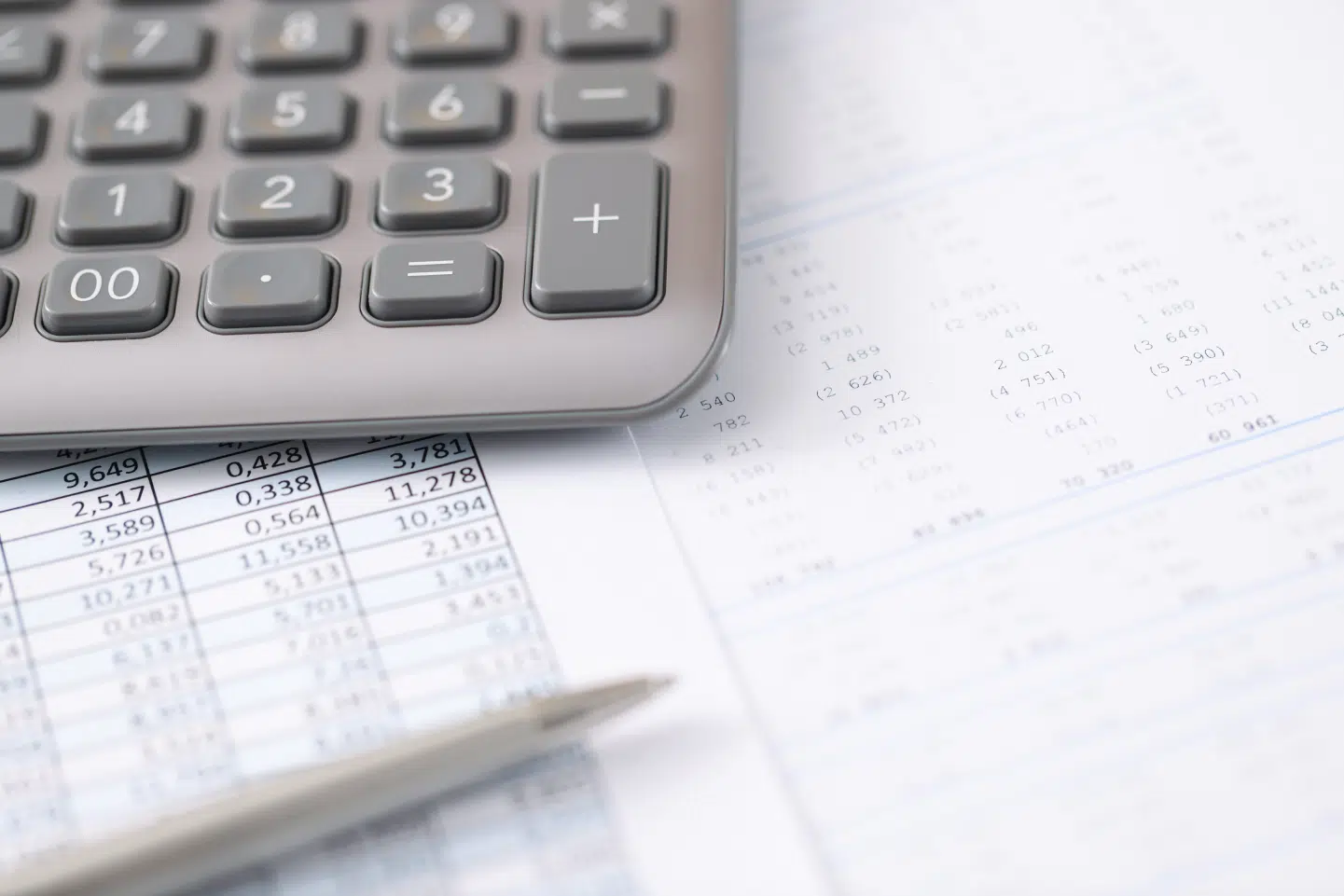 Close-up of a calculator on top of financial documents, representing wage calculations and employer record-keeping requirements.