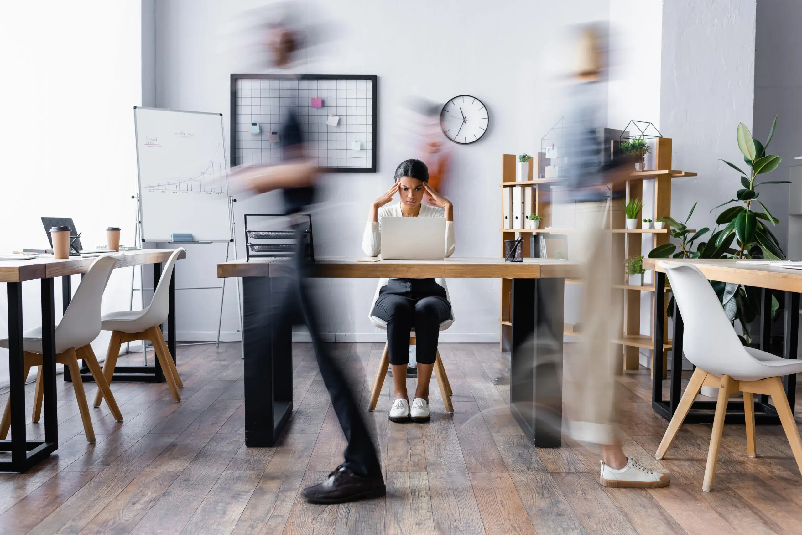 businesswoman touching head while suffering from migraine in office